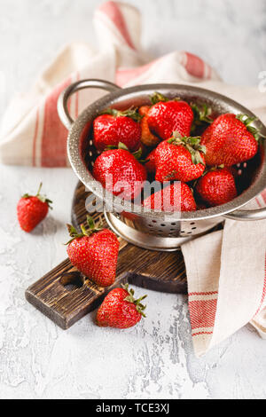 Frische Beeren Erdbeeren in ein Sieb auf grauem Hintergrund Stockfoto