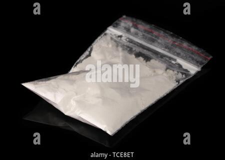 Kokain im Paket auf schwarzem Hintergrund Stockfoto