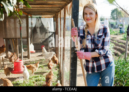 Lächelnden jungen weiblichen professionellen Landwirt bei Chicken House auf der Farm Stockfoto