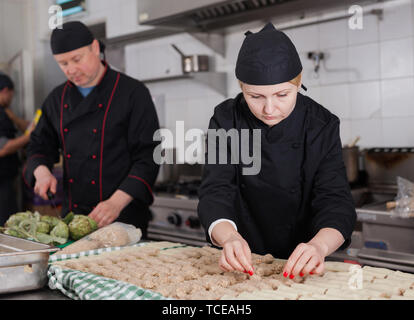 Qualifizierter Frauen kochen Vorbereiten von traditionellen Cannelloni gefüllt mit Hackfleisch im Restaurant Küche Stockfoto