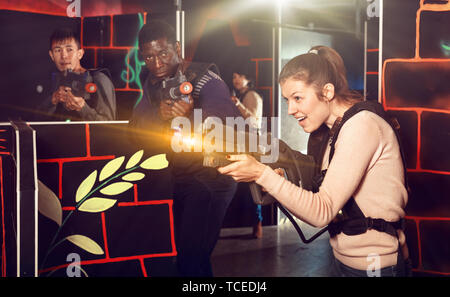 Portrait der junge Mann und die Frau mit dem Laser Pistolen spielen Laser Umbau auf dem dunklen Labyrinth Stockfoto
