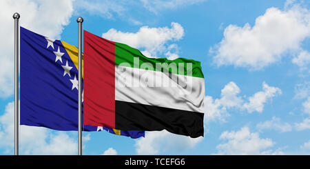 Bosnien und Herzegowina und die Vereinigten Arabischen Emirate Flagge im Wind gegen Weiße bewölkt blauer Himmel zusammen. Diplomatie Konzept, Internationale Beziehungen Stockfoto