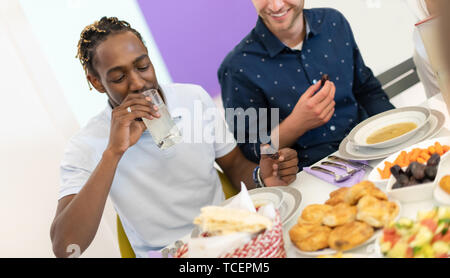 African American man Iftar gemeinsam das Abendessen genießen mit modernen multiethnischen muslimische Familie während des Ramadan Fest zu Hause Stockfoto