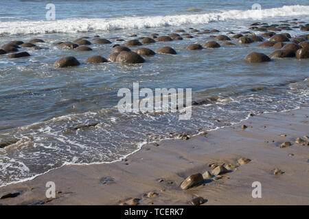 Landschaft von nasser Sandstrand mit kristallklarem Wasser wave mit runden Steinen und Kies an der Oberfläche Stockfoto