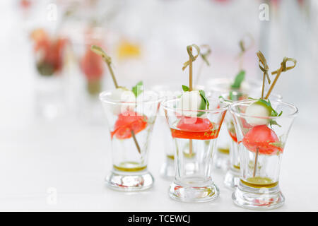 Vorspeise, Caprese. Cocktailtomaten, Mozzarella und Basilikum auf Spieße. . Pesto. Buffet beim Gala Dinner. Sortiment von kanapees. Bankett Service. Stockfoto