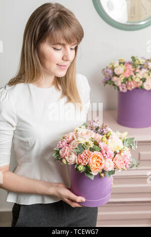 Florist Holding einen Blumenstrauß. Schöner Frühling Blumen im Kopf. Anordnung mit mix Blumen. Das Konzept der ein Blumengeschäft, ein kleiner Familienbetrieb Stockfoto