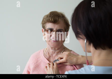 Ältere weibliche Patienten medizinische Prüfung Gläser weißer Hintergrund Stockfoto