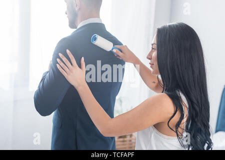 Fröhliche brunette Mädchen Reinigung formale Abnutzung des bärtigen Mann Stockfoto