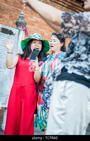 Chinesische Touristen machen gerne Urlaubsfotos auf ihrem Handy am Tha Phae Gate Chiang Mai, Thailand. Stockfoto