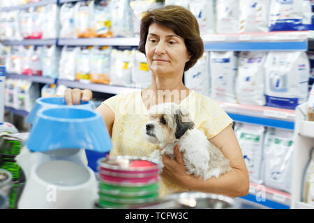 Ältere Frau besuchen Pet Shop auf der Suche nach Dog Bowl für die Fütterung Ihres süssen Havaneser Stockfoto