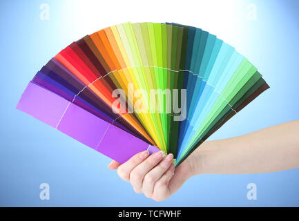 Hand mit hellen Farben auf blauem Hintergrund Stockfoto