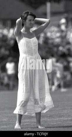 In Uxbridge Middlesex CCC Cricket 1990 eine junge Frau, die auf dem Boden während der Mittagspause in einer fließenden weißen sommerliches Kleid. Foto von Tony Henshaw Stockfoto