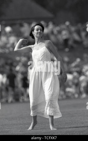 In Uxbridge Middlesex CCC Cricket 1990 eine junge Frau, die auf dem Boden während der Mittagspause in einer fließenden weißen sommerliches Kleid. Foto von Tony Henshaw Stockfoto