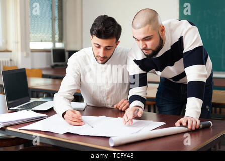 Porträt von zwei junge Kerle, die auf Ihren studentisches Projekt am Schreibtisch im Klassenzimmer Stockfoto