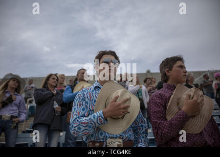 Heber City, Utah, USA. 7. Juni 2019. Teenage Männer halten ihre Cowboys Hüte über ihre Herzen, als sie die Nationalhymne am Utah High School Rodeo Association Finale in Heber City Utah, Juni 7, 2019 hören. Studierende aus der ganzen Staat Utah versammelt in Barrel Racing zu konkurrieren, Pole Bending, Ziege Binden, Breakaway Roping, Kuh, Stier reiten, Reiten ohne Sattel, Sattel bronc Reiten, Binden, Abseilen, Steer Wrestling und Team Roping. Credit: Natalie Behring/ZUMA Draht/Alamy leben Nachrichten Stockfoto