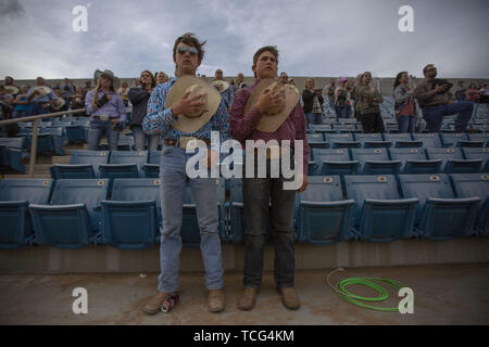 Heber City, Utah, USA. 7. Juni 2019. Teenage Männer halten ihre Cowboys Hüte über ihre Herzen, als sie die Nationalhymne am Utah High School Rodeo Association Finale in Heber City Utah, Juni 7, 2019 hören. Studierende aus der ganzen Staat Utah versammelt in Barrel Racing zu konkurrieren, Pole Bending, Ziege Binden, Breakaway Roping, Kuh, Stier reiten, Reiten ohne Sattel, Sattel bronc Reiten, Binden, Abseilen, Steer Wrestling und Team Roping. Credit: Natalie Behring/ZUMA Draht/Alamy leben Nachrichten Stockfoto