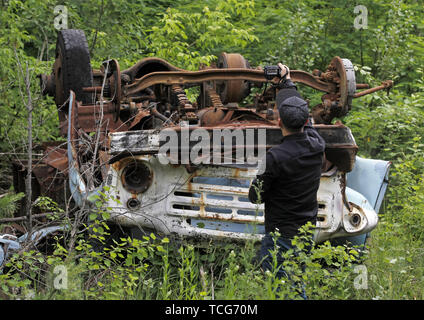 Pripyat, Ukraine. 7. Juni 2019. Ein Besucher nimmt Fotos eines havarierten auto in die Sperrzone von Tschernobyl in der verlassenen Stadt Pripyat. Der HBO-TV-Miniserie Tschernobyl, in den USA und in England im Mai 2019 uraufgeführt, schildert die Zeit nach der Katastrophe, einschließlich der Reinigung und die anschließende Untersuchung. Credit: ZUMA Press, Inc./Alamy leben Nachrichten Stockfoto