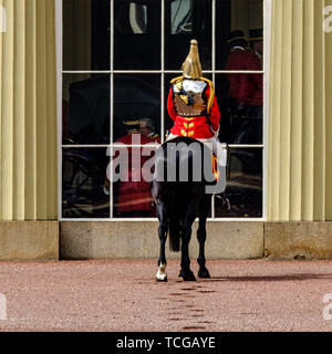 London, Großbritannien. 08 Juni, 2019. Eine alleinige Life Guard in den Palast quadrange und wartet als Mitglieder der Königlichen Familie ihren Wagen an der Parade Masse an die Farbe zu reisen, der offiziellen Feier Geburtstag der Königin am Samstag, den 8. Juni 2019 im Buckingham Palace, London. Dieses Jahr das erste Bataillon Grenadier Guards trabten thier Farbe. Im Bild: Die Schlossanlage und Tor sind refelected in Uniform. Bild von der Credit: Julie Edwards/Alamy Live News Credit: Julie Edwards/Alamy leben Nachrichten Stockfoto