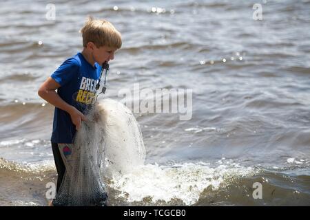 Ein Junge Fische mit einer Besetzung net in der Bucht. Stockfoto