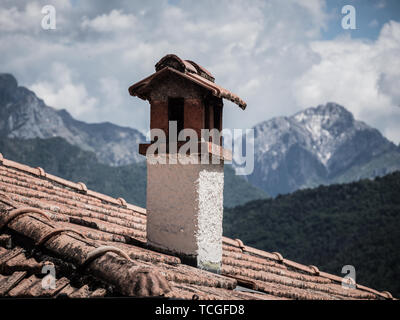 Bild des alten Schornstein mit Schnee Alpen im Hintergrund Stockfoto