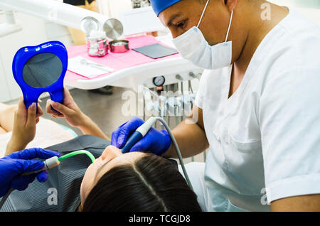 Zahnarzt und sein Assistent, eine gründliche Untersuchung des Patienten in der Zahnarztpraxis Stockfoto