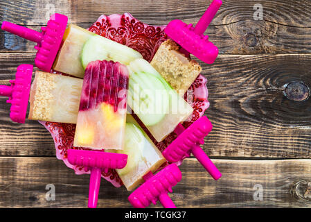 Hausgemachte Vegan Popsicle aus gefrorenen Apfelsaft und Beeren, Äpfel und Cookies auf dunklen rustikalen Hintergrund. Sommer essen Konzept. Ansicht von oben. Kopieren Raum f Stockfoto