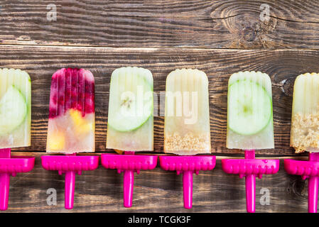 Hausgemachte Vegan Popsicle aus gefrorenen Apfelsaft und Beeren, Äpfel und Cookies auf dunklen rustikalen Hintergrund. Sommer essen Konzept. Ansicht von oben. Kopieren Raum f Stockfoto