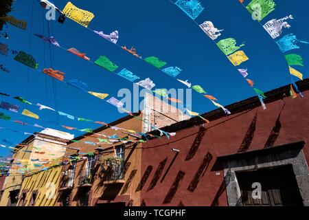 Papier fiesta Banner gegen einen klaren blauen Himmel schmücken Quebrada Straße im historischen Zentrum von San Miguel de Allende, Guanajuato, Mexiko. Stockfoto