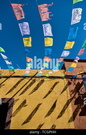 Papier fiesta Banner gegen einen klaren blauen Himmel schmücken Quebrada Straße im historischen Zentrum von San Miguel de Allende, Guanajuato, Mexiko. Stockfoto