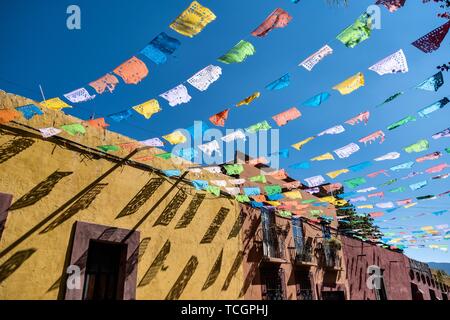 Papier fiesta Banner gegen einen klaren blauen Himmel schmücken Quebrada Straße im historischen Zentrum von San Miguel de Allende, Guanajuato, Mexiko. Stockfoto