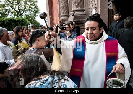 Eine römisch-katholische Priester segnet versammelt Haustiere und die Besitzer der Tiere während der jährlichen Segnung der Tiere am Fest des San Antonio Abad an Oratorio de San Felipe Neri Kirche im historischen Zentrum von San Miguel de Allende, Guanajuato, Mexiko. Stockfoto