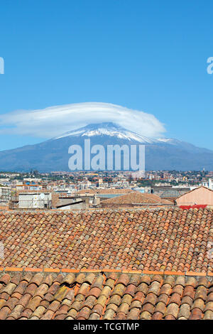 Vertikale Fotografie erfassen schöne Stadtbild von Catania, Sizilien, Italien mit den berühmten Vulkan Ätna im Hintergrund. Die Dächer der historischen Gebäuden. Schnee auf der Spitze des Berges. Stockfoto