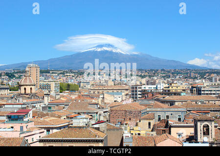 Majestätischen Ätna mit Blick auf die sizilianische Stadt Catania, Italien. Rauch Wolke über den berühmten Vulkan, Schnee auf der Spitze. Dominante der Stadt ist die Kuppel der Kathedrale von Catania der Hl. Agatha. Stockfoto