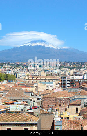 Vertikale Bild erfassen berühmte Ätna mit Blick auf die sizilianische Stadt Catania, Italien. Rauch Wolke über den berühmten Vulkan, Schnee auf der Spitze. Die schöne Stadt ist ein beliebtes Touristenziel. Stockfoto