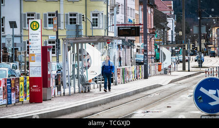 Freiburg im Breisgau, Deutschland - 31. Dezember 2017: Mann neben eine elektrische Straßenbahn an einem Wintertag Stockfoto