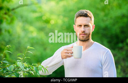 Frühstücksbuffet Zeit. Tee trinken Outdoor. Kaffee am Morgen. gesunde Lebensweise. Natur und Gesundheit. ökologisches Leben für den Menschen. Mann im grünen Wald. reifer Mann bei einer Tasse Tee. Morgen vibes. Stockfoto