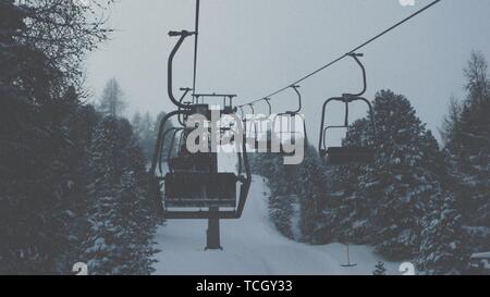 Hochseilbahn in den verschneiten Bergen für Touristen und Skifahrer Stockfoto