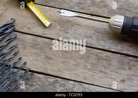 Bohrmaschine Maßband mit vielen Bohrer auf einem alten Holztisch. Stockfoto