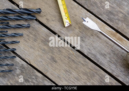 Bohrmaschine Maßband mit vielen Bohrer auf einem alten Holztisch. Stockfoto