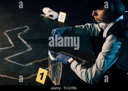 Investigator in Uniform sammeln Beweise am Tatort Stockfoto