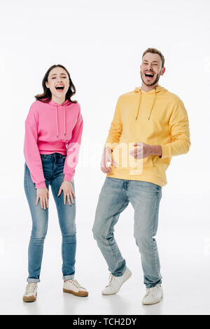 Fröhlicher junger Mann und die Frau in der blauen Jeans und Hoodies lachend bei Kamera schaut auf weißem Hintergrund Stockfoto