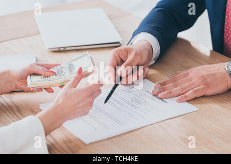 Teilweise mit Blick auf die Unternehmer auf Unterschrift Ort im Darlehensvertrag in der Nähe von client Geldhaltung Stockfoto