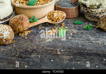 Gesunde Snacks. Fitness diätetische Lebensmittel. Sesam Halva. Flocken, Chia Samen in zwei Schüsseln und Löffel. Kozinaki mit Sesam, Erdnüsse, Sonnenblumenkerne, Kürbiskerne Stockfoto