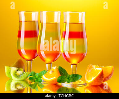 Grütze in Gläsern und Früchte auf gelbem Hintergrund Stockfoto