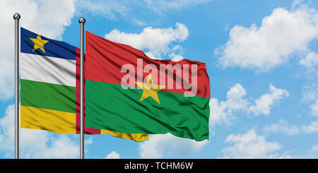 Zentralafrikanische Republik, Burkina Faso Flagge im Wind gegen Weiße bewölkt blauer Himmel zusammen. Diplomatie Konzept, internationale Beziehungen. Stockfoto