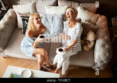 Zwei glückliche Frauen Lachen und Genießen mit Kaffee Stockfoto
