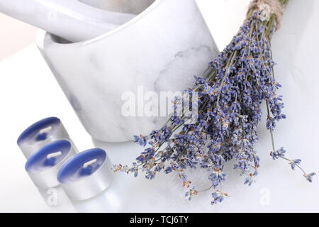 Lavendelblüten mit Mörtel und Kerzen isoliert auf weißem Stockfoto