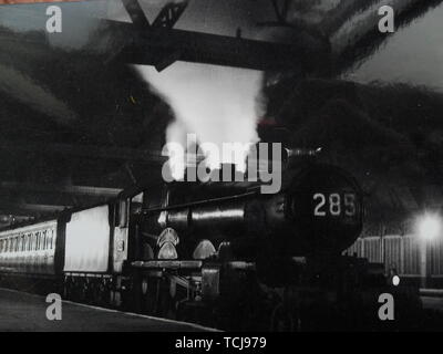 Eine Nacht Express fährt Shrewsbury unter dem grossen schwarzen Dach. Dampfzug in Shrewsbury Bahnhof in den 1950er Jahren. Shrewsbury, Shropshire, England, Großbritannien Stockfoto