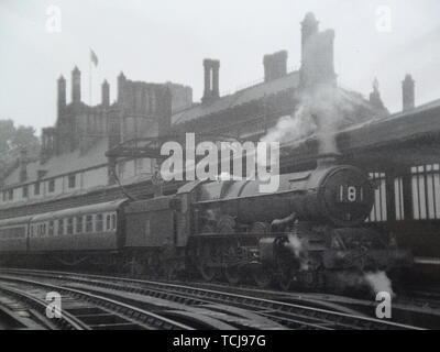 König klasse Lokomotive nimmt Wasser in Shrewsbury. Dampfzug in Shrewsbury Bahnhof in den 1950er Jahren. Shrewsbury, Shropshire, England, Großbritannien Stockfoto