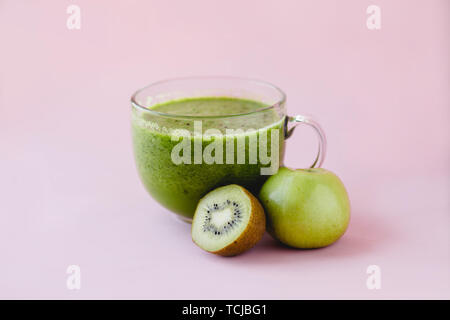 Gesunden grünen Smoothie mit Kiwi und Green Apple in ein Glas Schale auf rosa Hintergrund Stockfoto